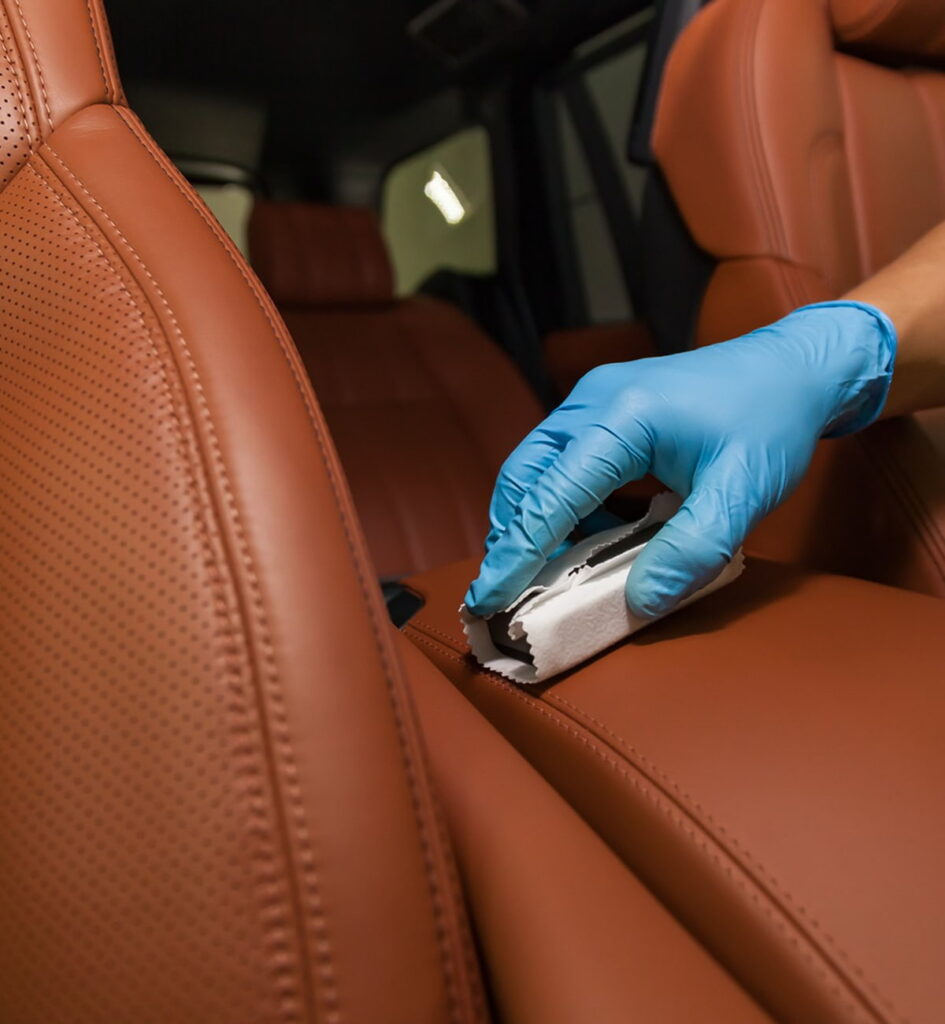 A person cleaning the upholstery while wearing a blue glove